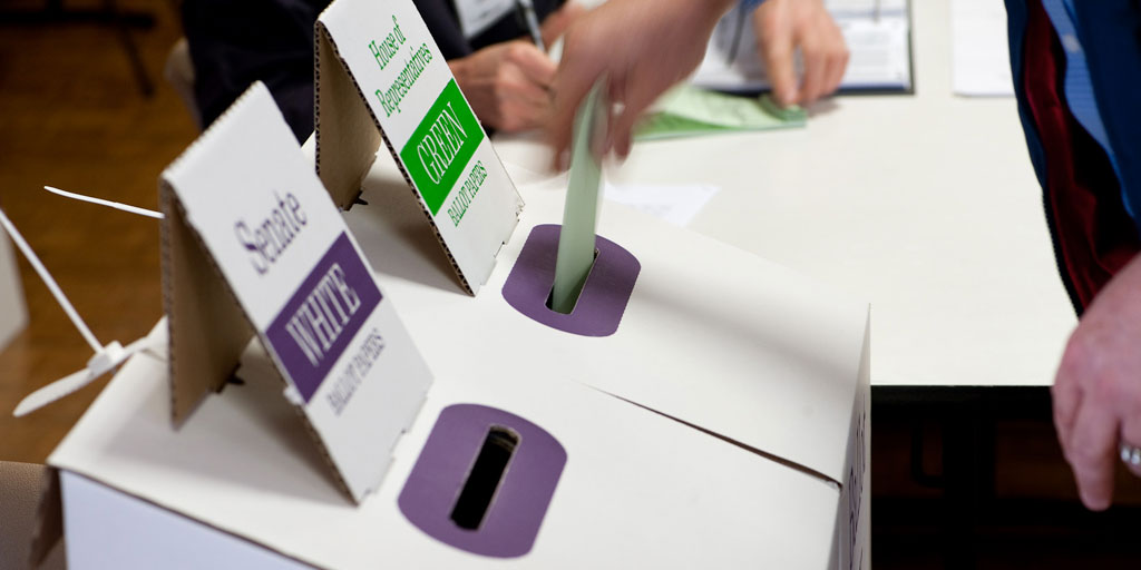 A voter places ballot paper in ballot box