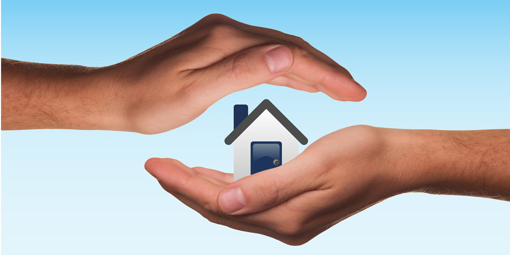 Image of hands cupping a house illustrating SMSFs and property transfer