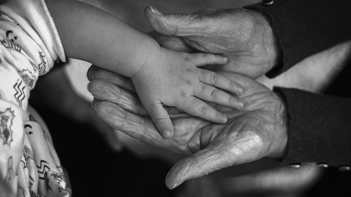 Elderly and child's hands touching